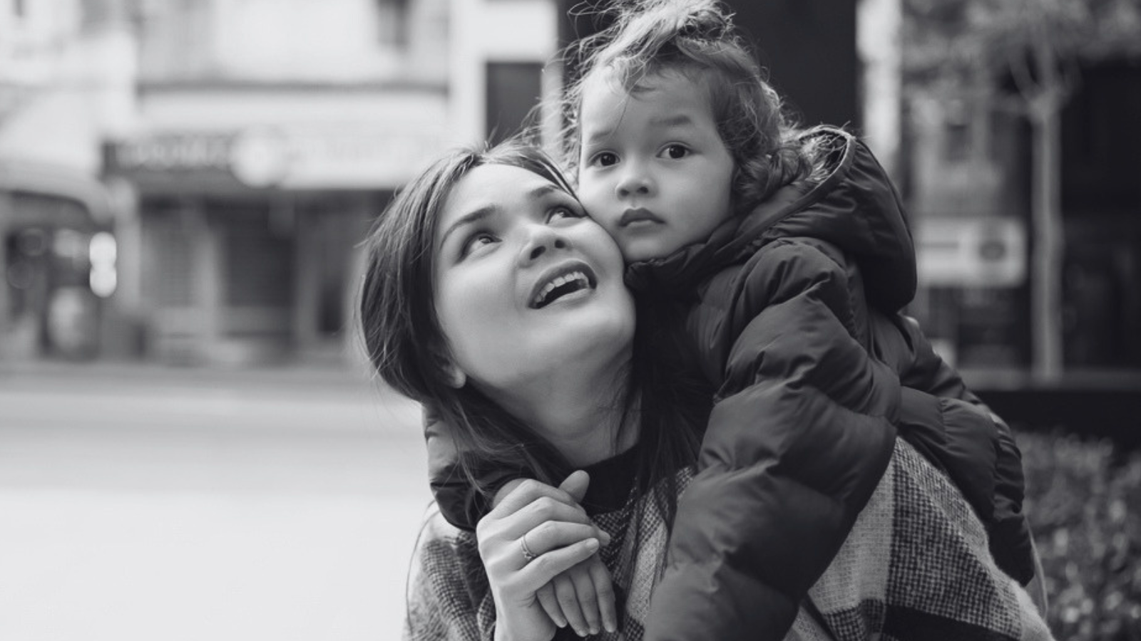 A young woman smiling at her daughter who is having a piggyback